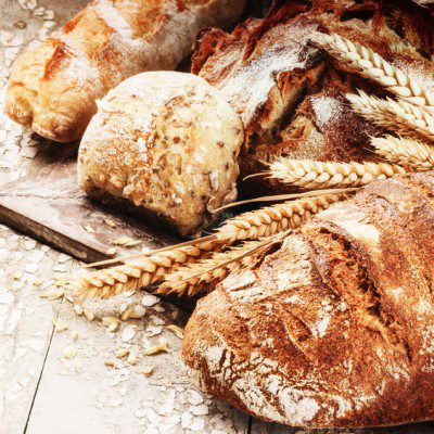 Assorted artisan breads with wheat kernels.