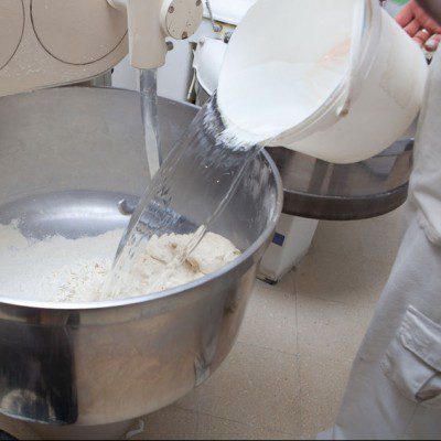 Adding water for food processor to kneading dough for bread. 